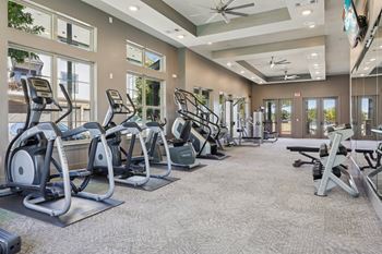 A spacious gym with treadmills, elliptical machines, and other exercise equipment.
